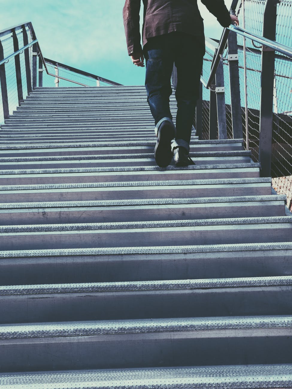 man walking on gray stairs